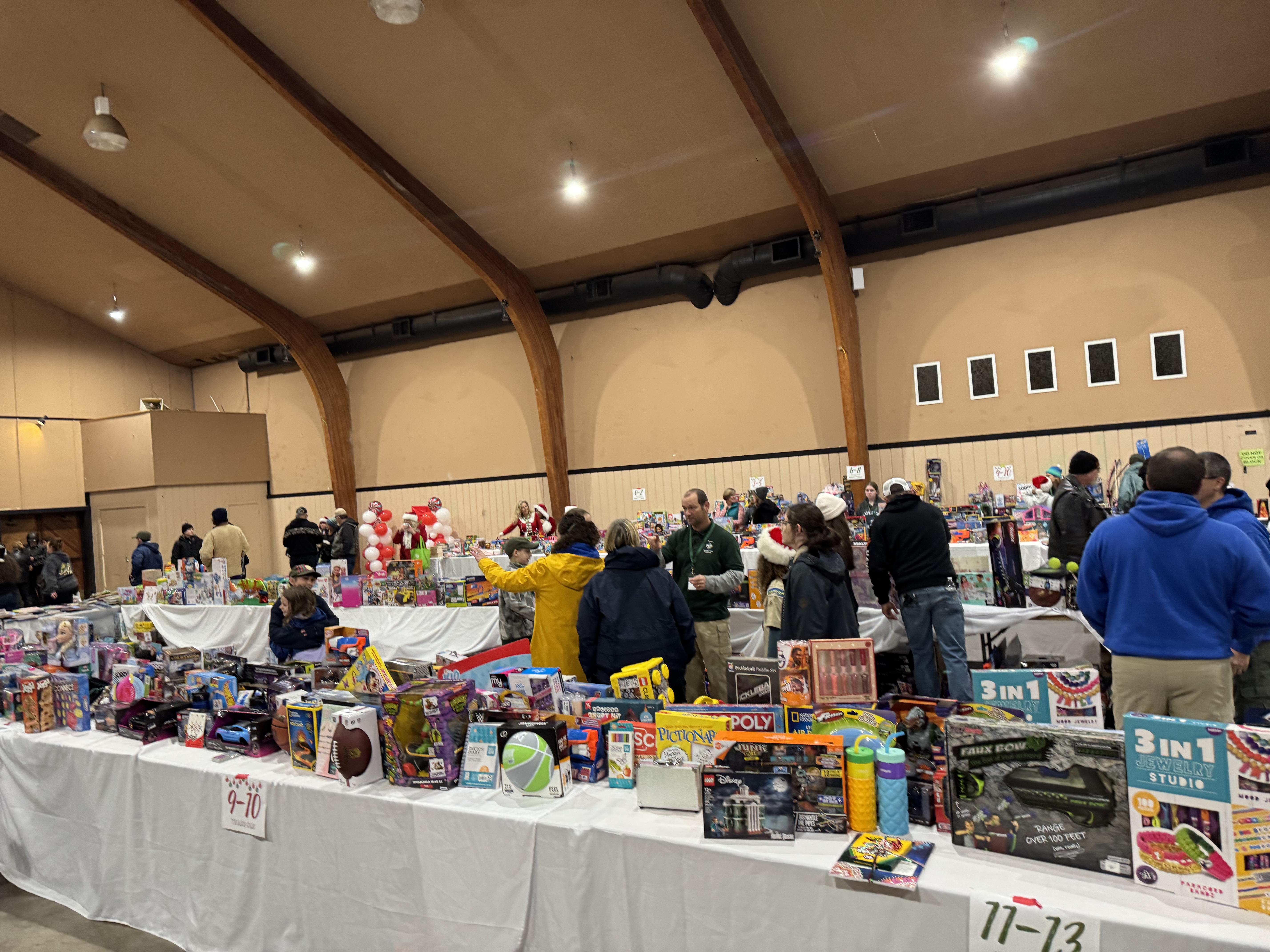Gift tables arranged by age group inside the Toy Run event hall.